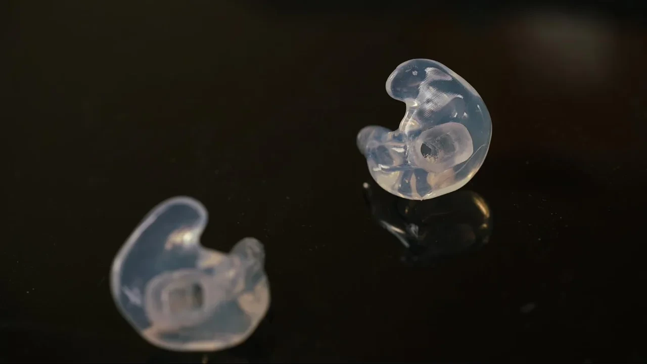Custom Big Ear adapter for the Bose ProFlight, a clear molded pair on a dark surface